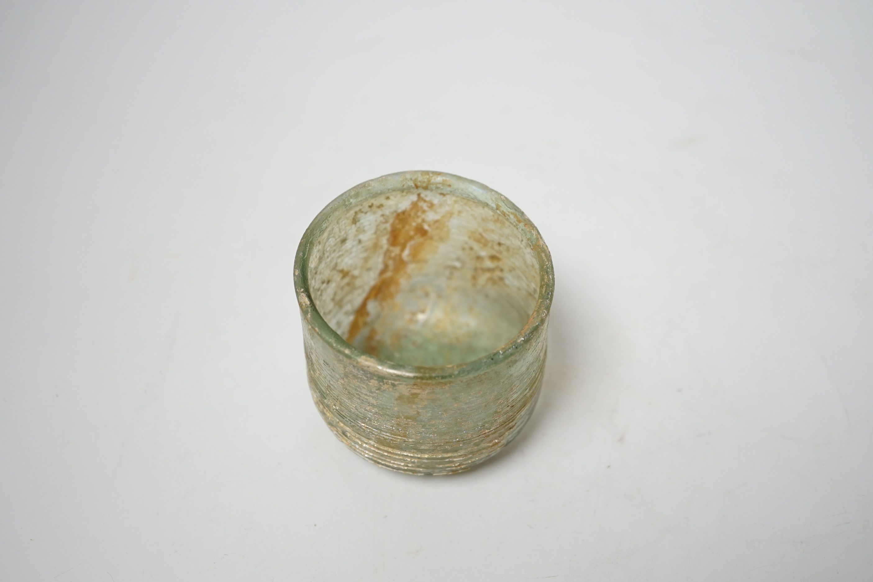 A Roman iridescent glass cup or tumbler, probably 2nd century AD, 7cm